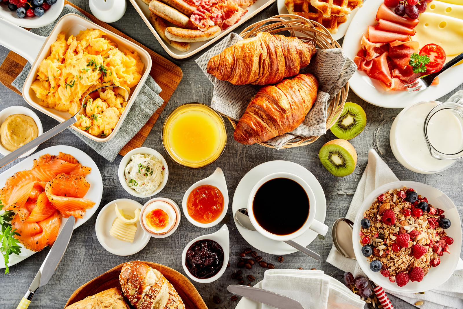 breakfast catering spread with pastries, fruit, and coffee service, bright morning light